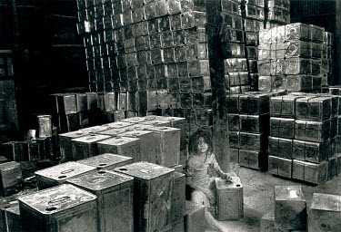 Child labour: a young girl employed in a workshop recycling industrial oil cans.