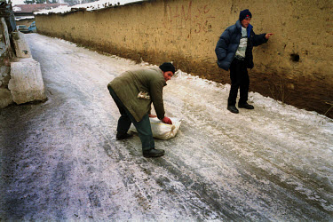 A Pristina resident finds the best way of transporting a sack of beans down an icy street.
