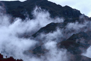 Quechua Indian woman (bottom left) walking through mist in the mountains.