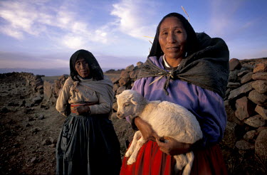 A shepherdess holding a lamb.