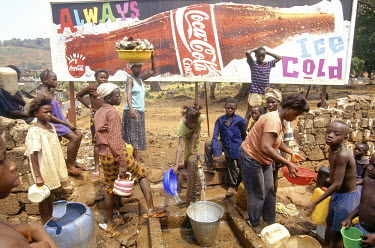 Coca Cola billboard by stand pipe - many houses in the capital still don't have running water.