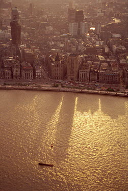 The Peace Hotel (left) and Bank of China (right) create long shadows on the Huangpu river.