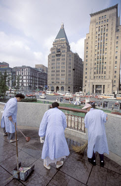 Cleaning the Bund, in front of the Peace Hotel (left) and the Bank of China (right).