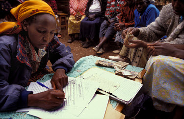 Woman signing for a loan as part of a micro-credit scheme run by a community self-help group.