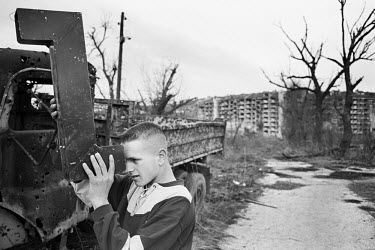 A young boy playing with a periscope while exploring the wreckage of the old frontline following the end of the war.