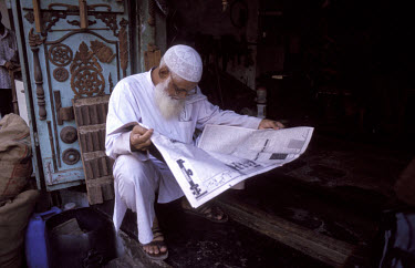 Muslim man reading the newspaper in the Kalbadevi district of the city.
