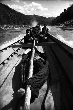 Karenni soldiers returning from the front line with the body of a dead comrade. They take a long-tail boat down the river back to their camp, close to the border with Thailand.