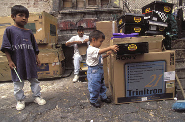 A father and his sons making a living by recycling television boxes.