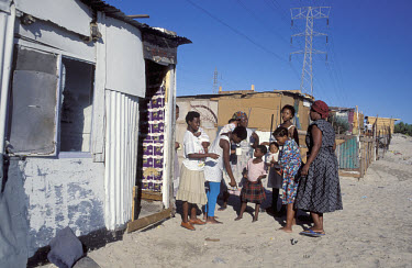 Familes in Khayelitscha Township. Electricity lines run overhead, but the homes in the township are not connected to them.