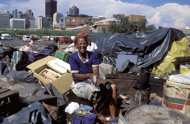Woman living amongst the rubbish in the midst of Africa's most powerful financial district.