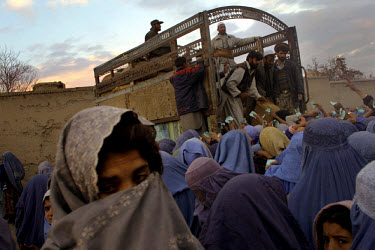 Afghan women crowd around a UN World Food Programme truck carrying wheat at an officially-designated food distribution point in central Kabul.