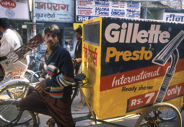 Westernisation: man pulling delivery cart with Gillette razor advert emblazoned on it's side.