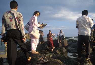 Kanyakumari (Cape Comorin), on the southern tip of India, is an important place of pilgrimage for Hindus. Middle class Indian tourists explore the rocks, with poorer pilgrims behind.