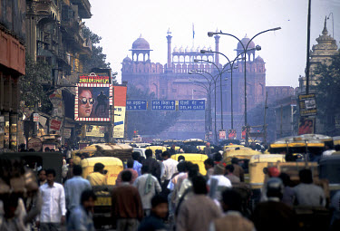 Movie poster above rush hour traffic jam on Chandni Chowk in the old city, with the Lahore Gate of the Red Fort behind.