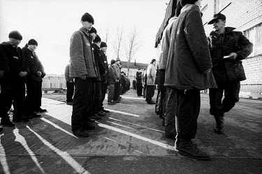 Inmates in a juvenile prison lining up for the first roll call of the day in front of the main prison building. After this half of the inmates are taken for their school classes while the other half g...