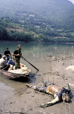 The decomposing bodies of murdered civilians dumped in the Drina river, some tied together with barbed wire. A boat tries to collect and identify the bodies. Many of the dead came from the Foca area....
