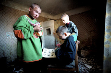 Aleksie (13, right), Janis (14, middle) and Lauris (16, right) in a disused appartment block where they go to keep warm and sniff glue. There are approximately 10,000 street children in Riga. Most of...