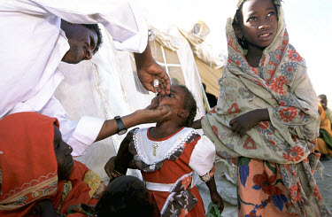 A young girl receives her polio vaccination as part of an Africa-wide campaign to eradicate polio, sponsored by the World Health Organisation (WHO). The campaign had been promoted through loudspeaker...