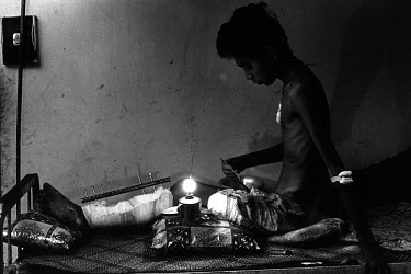 A young landmine victim eating by the light of an oil lamp in Siem Reap hospital. A surgeon from Medecins Sans Frontieres (MSF) has recommended his leg be amputated, but the patient refused and is goi...