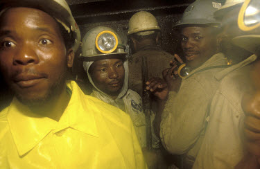 Miners on their way underground by lift in a gold mine.