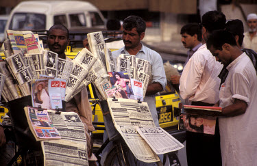 Men gathered around a newspaper stall.