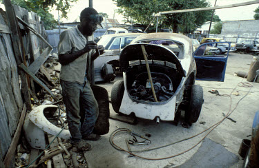 Car mechanic preparing a marijuana joint, Almond Town.