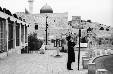 Waiting at the bus stop next to the Wailing Wall (Western Wall), with the Dome of the Rock mosque in the background. A bombing campaign on buses meant that many people were avoiding public transport.
