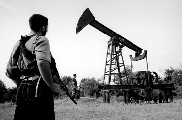 Chechen fighters inspect an old oil well. The oil infrastructure in Chechnya was devastated after years of war and neglect, yet people still made their own small wells to try to retrieve, refine and s...