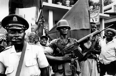 Policeman and soldier at a rally organised by the Front for Haitian Advancement and Progress (FRAPPE).