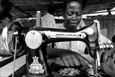 A girl works at a sewing machine, part of a skills training workshop at a UNICEF-assisted centre run by GUSCO, a local NGO. The scheme provides psychological counselling, vocational training and other...