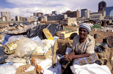 An old woman living amongst the rubbish in the centre of Africa's most powerful financial district.
