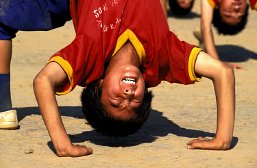 Shaolin. Boy suffering during training at martial arts school close to the famous temple.