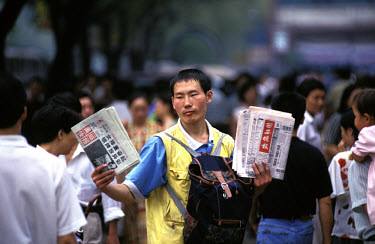 Xian. Youth selling newspapers on the street.