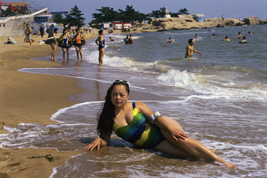 Young woman posing for a souvenir photo taken by a beach photographer, at this resort on the Bohai Gulf. Once almost exclusively reserved for party officials and foreign diplomats, it is now popular w...