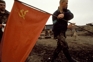 A Russian army batallion pulls out of Chechnya after the Moscow government agreed to withdraw troops. The batallion kept the Soviet flag flying while they were at war.
