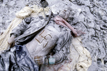 The snow-covered body of an unidentified man lies in the street in the village of Piervomaiskoe in the aftermath of a hostage-taking by Chechen rebels. One of the villagers drew the swastika sign on h...