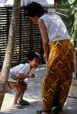 A woman beating a child in the street.