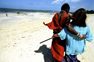 Masai man (Musa) in traditional clothes together with his German girlfriend Brigitta. The beaches around Mombasa are well known to tourists from Europe, not only for their sea, sun and sand but also f...