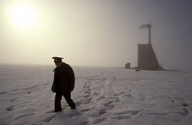 Colonel Smagulov, the officer in charge of radition monitoring at Kurchatov, returning from checking radiation levels on the site of the very first Soviet atomic test in 1949. The tower in the backgro...