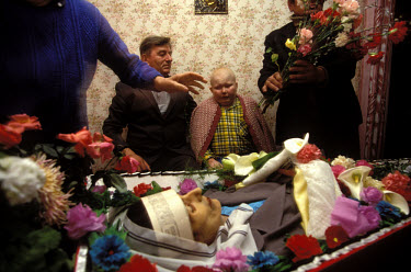 The funeral of Elena Dolina, who died of stomach cancer aged 38. Her son Yevgeny, in the background, is dying from leukaemia. Her father, Vasily Dolin, on the boy's right, was an agricultural worker o...
