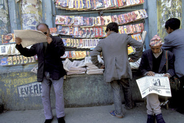 Men reading at a newsstand.