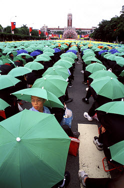 Students wearing coloured umbrella hats take part in Taiwan's National Day celebrations, with the Presidential Palace in the background.
