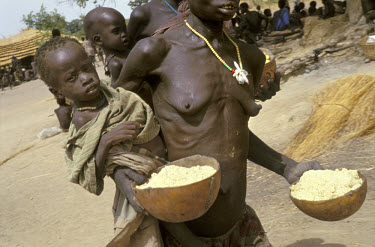 Dinka people collect food aid supplied by the UN WFP (World Food Programme). The 1998 famine in Southern Sudan affected around 2.6 million people. In the worst-hit region of Bahr el Ghazal, most of th...