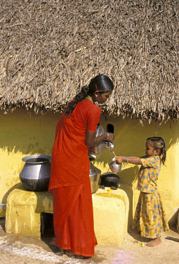 Mother pouring a drink of water for her daughter in Permangalam. The water comes from the village bore well installed by the NGO Wateraid.