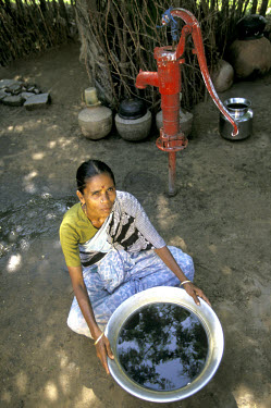 A woman shows how the groundwater supplying the village well in Madathuluppam has been polluted by local prawn farms.
