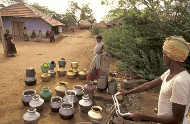 Woman collecting water from the village tap, installed by the NGO Wateraid.