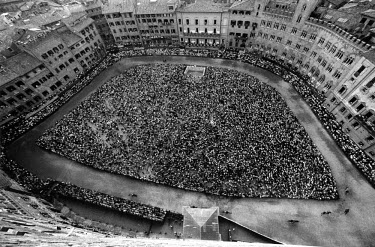 An aerial view of the Piazza del Campo on the day of the race.Twice each summer, the square in the medieval Tuscan town of Siena is transformed into a dirt racetrack for Il Palio, the most passionate...