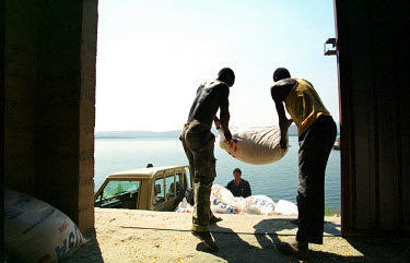 Workers at Zambian NGO Harvest Help's warehouse in Siavonga, loading sacks of United Nations World Food Programme-donated American corn for distribution by boat to outlying areas along Lake Kariba. Th...
