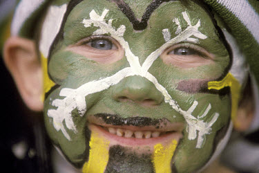 Young Celtic supporter, with the club's four-leafed clover badge painted on his face.The 'Old Firm' rivalry between Celtic and Rangers is renowned as the world's most intense football derby.