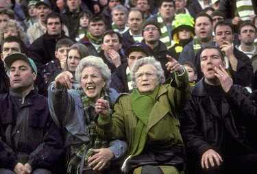 Celtic supporters, young and old, in the crowd at a match against Rangers.The 'Old Firm' rivalry between Celtic and Rangers is renowned as the world's most intense football derby.